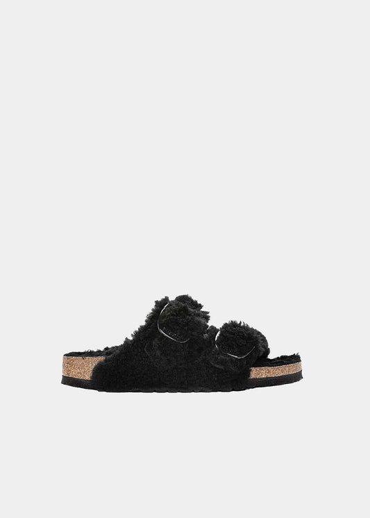 Mules Birkenstock Arizona Big Buckle Shearling en mouton noir, vue de profil – mules fourrées femme | Ann Tuil
