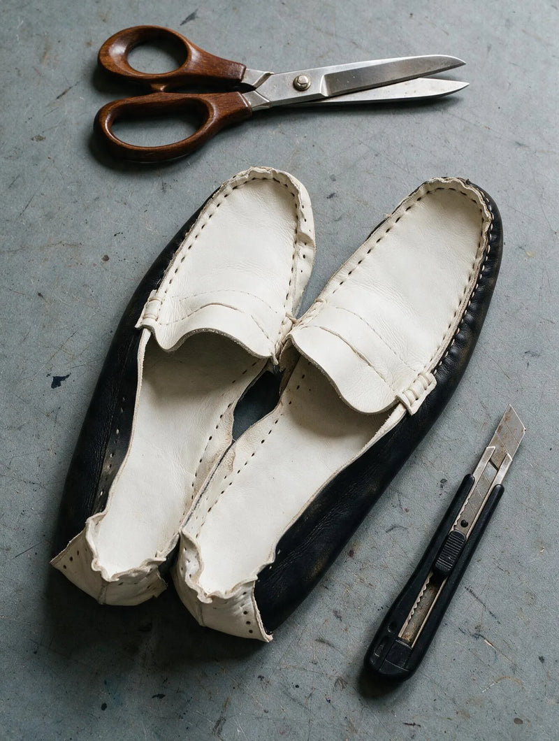 Mocassins en cuir cousus main sur l'établi d'un atelier de chaussures Ann Tuil